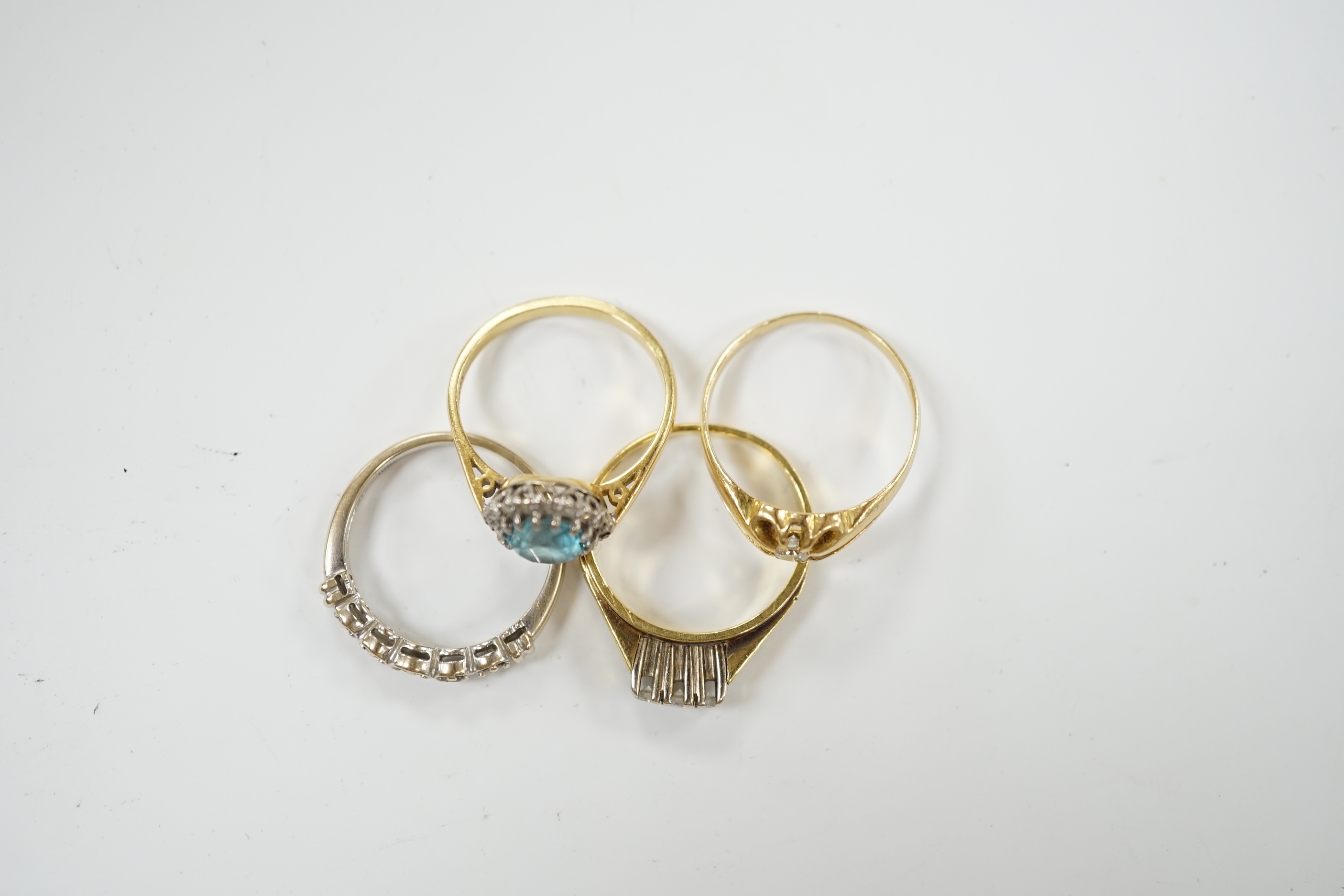 Three assorted 18ct and gem set dress rings, including blue zircon and diamond chip and claw set solitaire and one other yellow metal and gem set ring, gross weight 12.6 grams.